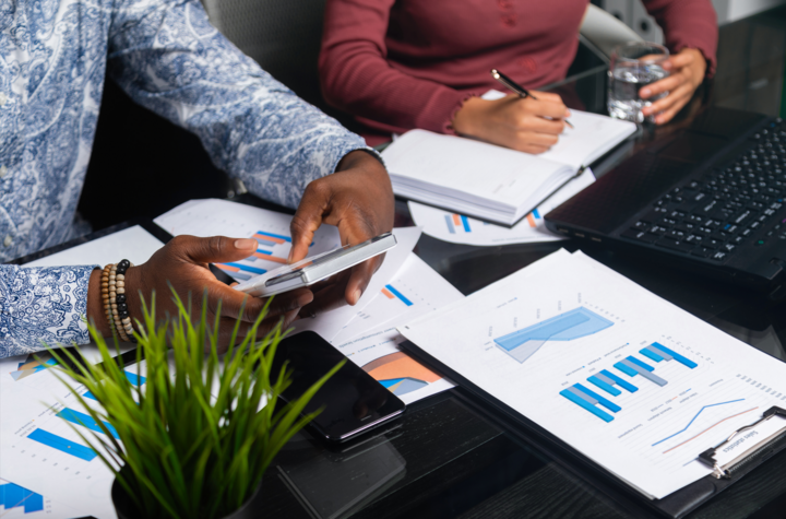 hands of people hold calculator figuring out beneficial ownership information reporting against background of financial documents in business